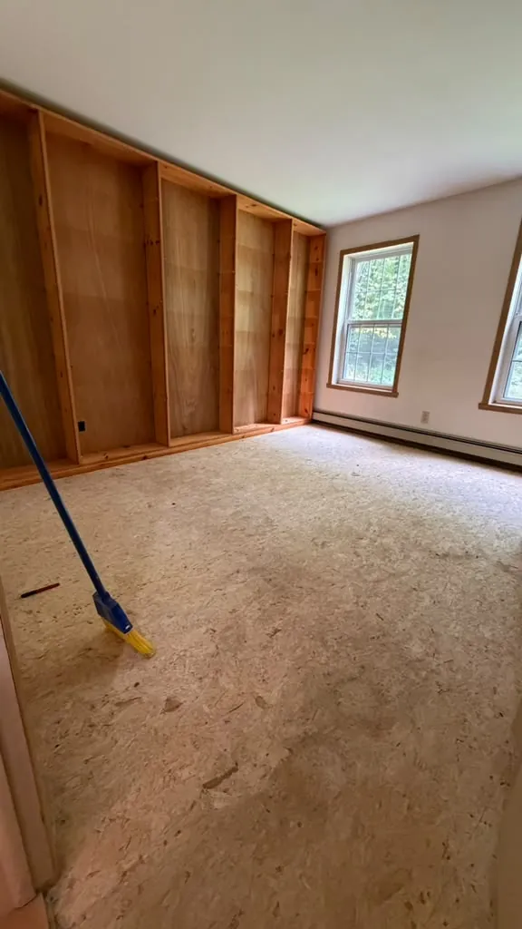 The same study before: flooring removed and original wood built-ins