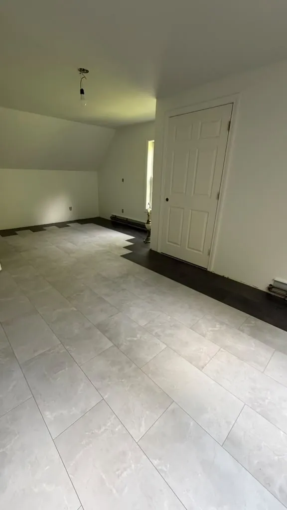 Attic bedroom with new flooring and white walls
